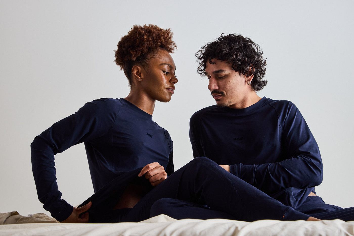 A couple resting in bed in navy ZedCore sleepwear