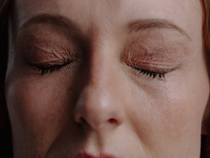 Menopause nightwear hero — woman with closed eyes, freckled skin, peaceful sleep